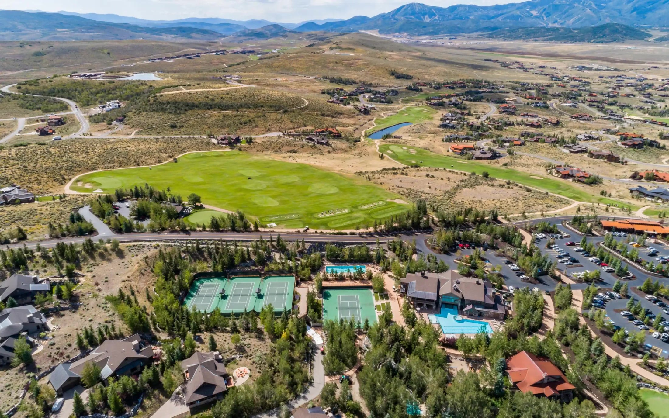 Aerial of a private club with golf, tennis, and the Wasatch mountains