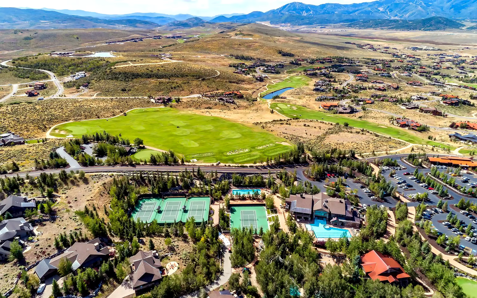 Aerial of Promontory club fairways, tennis, and pools, with mountains north of Park City