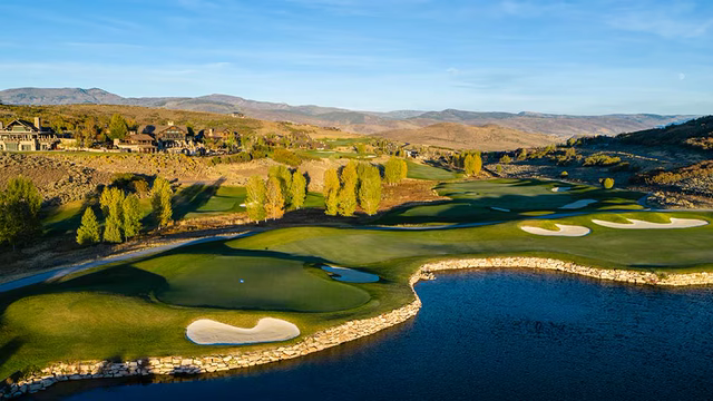 Aerial of a golf hole, fairway, and houses at Tuhaye, with mountains behind