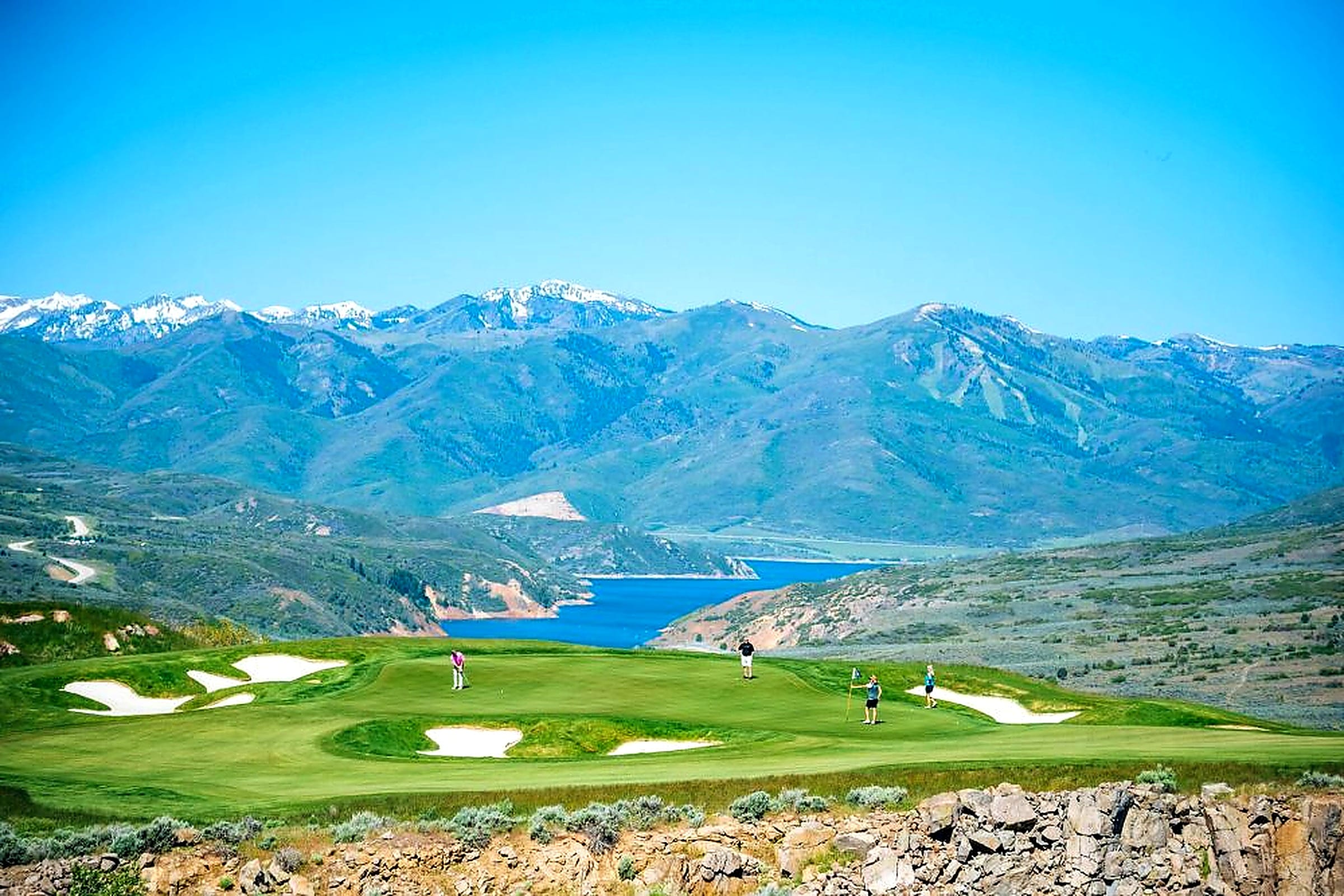 Aerial of a Victory Ranch fairway beside the lake, with the mountains behind